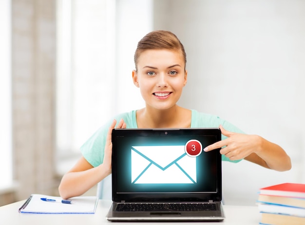 Photo picture of smiling student girl with laptop at school