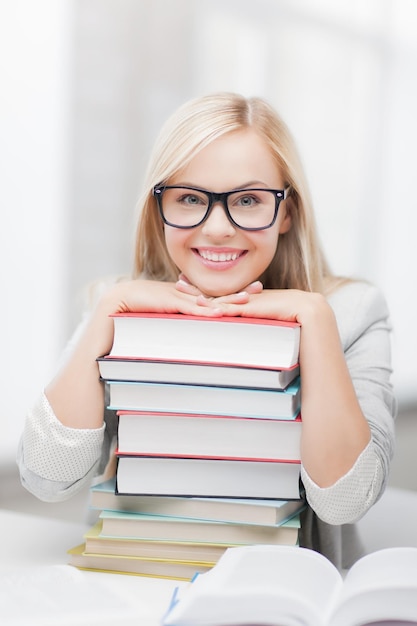 Foto di uno studente sorridente con una pila di libri