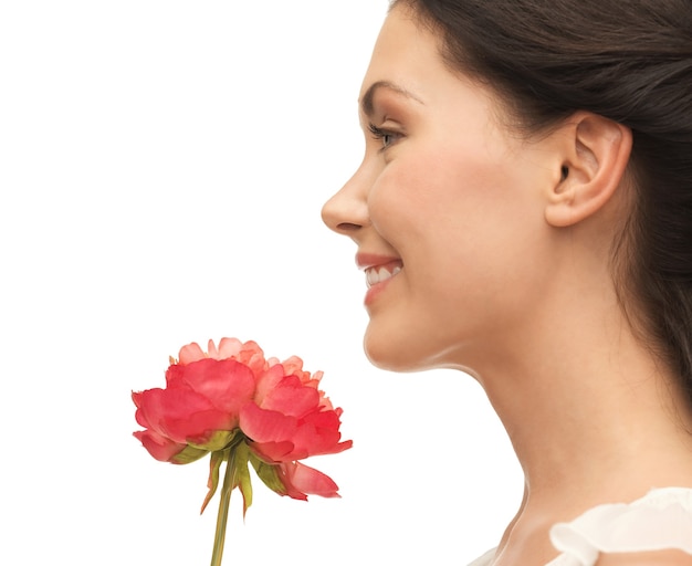 花の匂いを嗅ぐ笑顔の女性の写真
