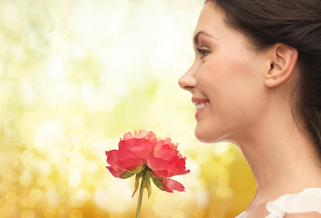花の匂いを嗅ぐ笑顔の女性の写真