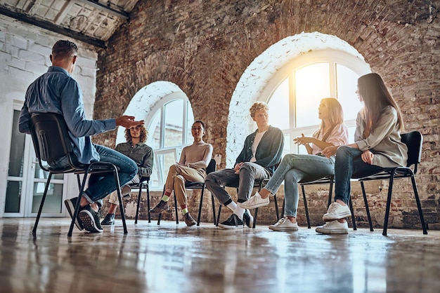 Picture of support group during meeting with professional therapist Sunbeam background Low angle