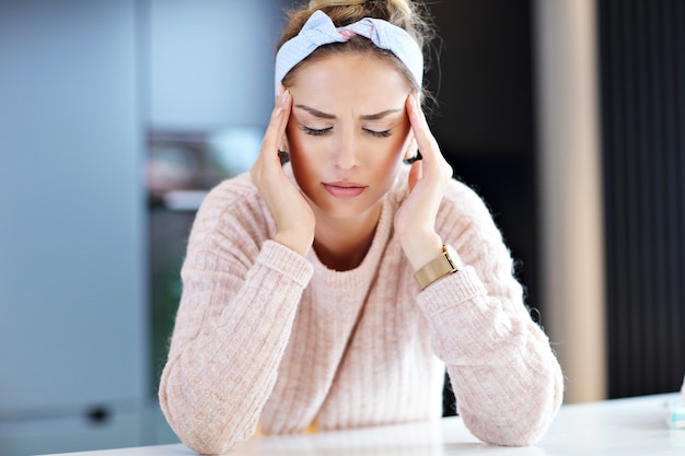 Photo picture of tired millennial woman resting head in the kitchen