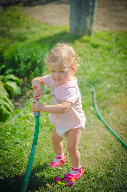 水ホースで遊んでいる幼児の女の子の写真