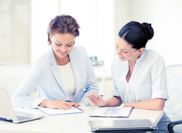 picture of two smiling businesswomen working in office