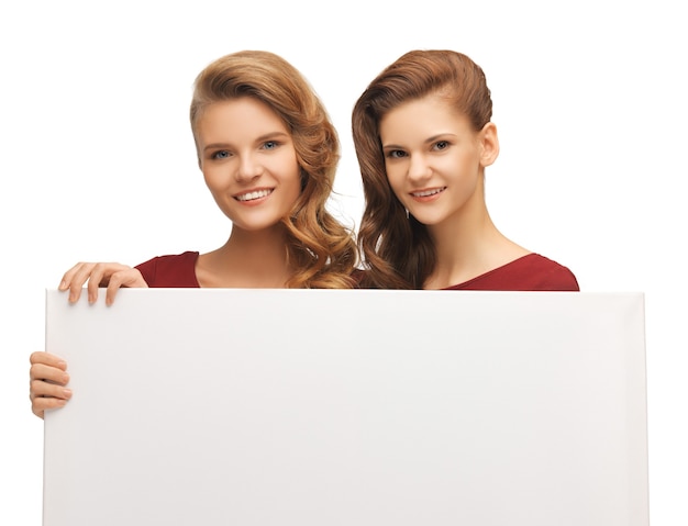 picture of two teenage girls in red dresses with blank board