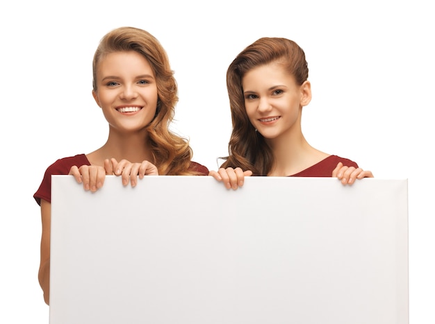 picture of two teenage girls in red dresses with blank board