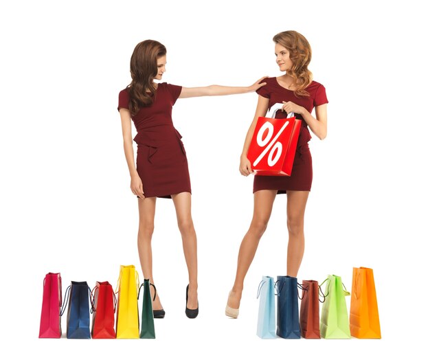 ショッピングバッグと赤いドレスを着た2人の10代の少女の写真