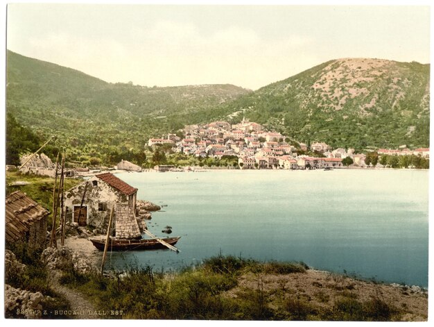 a picture of a village with a house on the water and a mountain in the background