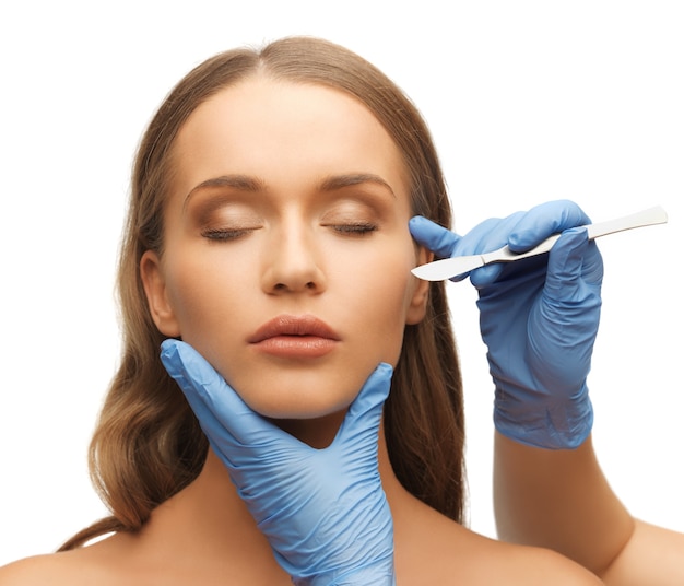 picture of woman face and beautician hands with scalpel