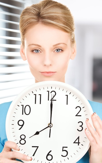 picture of woman holding big clock