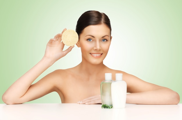 picture of woman with sponge and cosmetic bottles