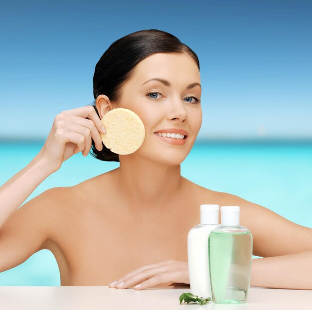 picture of woman with sponge and cosmetic bottles