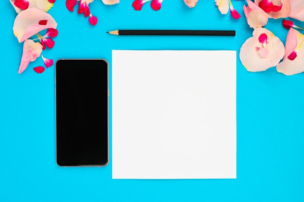 Picture for womens blog. Flat lay with flowers, notebook, smartphone and pencil on paper background