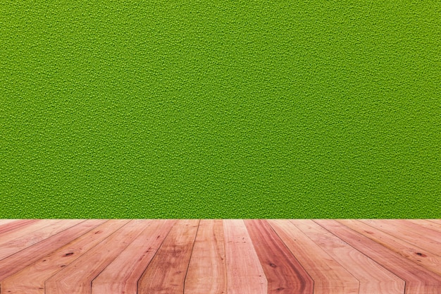 A picture of a wooden desk in front of an abstract background of green cloth.