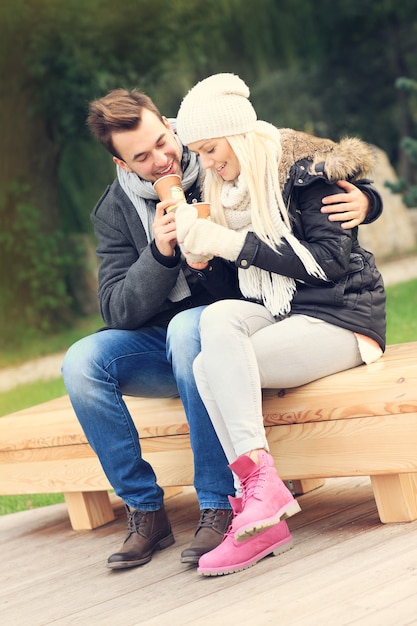 A picture of a young couple drinking coffee outdoors