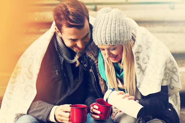 A picture of a young couple drinking tea outdoors