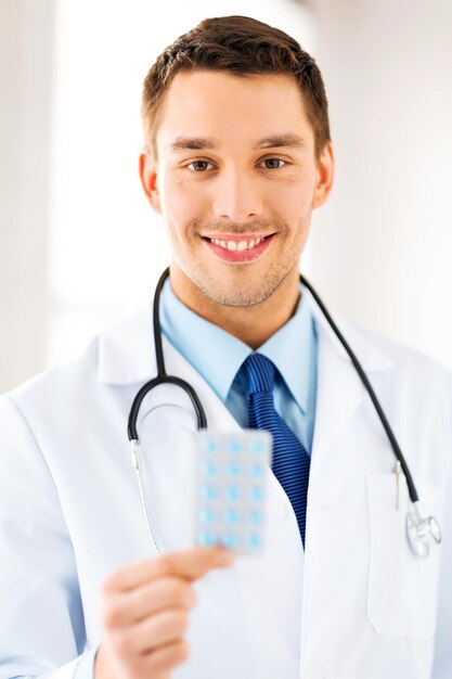 picture of young male doctor with pack of pills