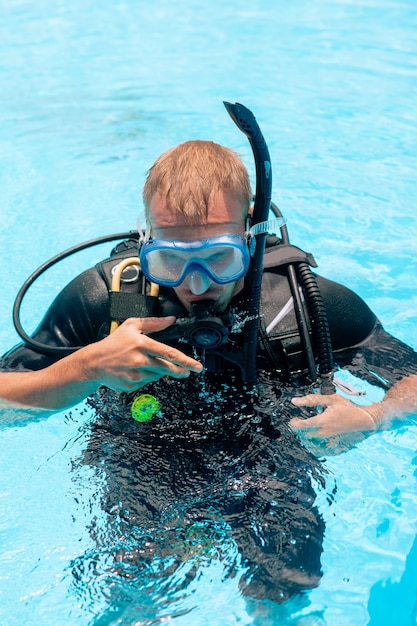 Picture of a young man in a snorkelling mask in a swimming pool