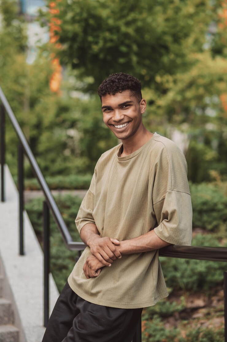Picture of a young man in a thsirt standing outside