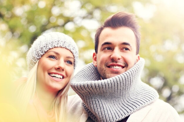 A picture of a young romantic couple in the park in autumn