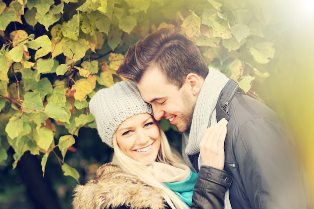 A picture of a young romantic couple in the park in autumn