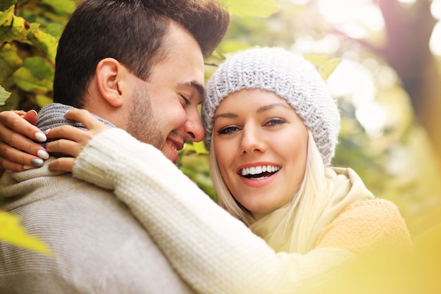 A picture of a young romantic couple in the park in autumn