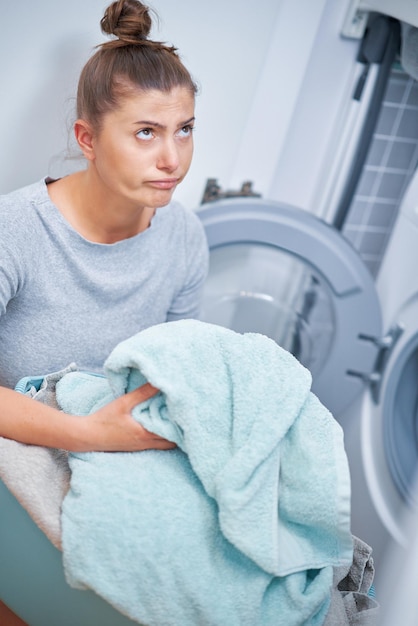 Picture of young woman making laundry work