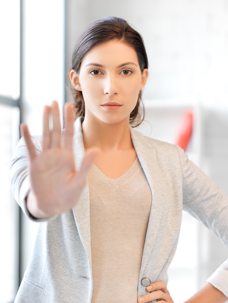 停止ジェスチャーをしている若い女性の写真