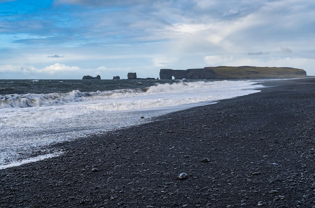 Picturesque autumn Dyrholaey Cape and rock formations view from Reynisfjara ocean black volcanic sand beach Vik South Iceland