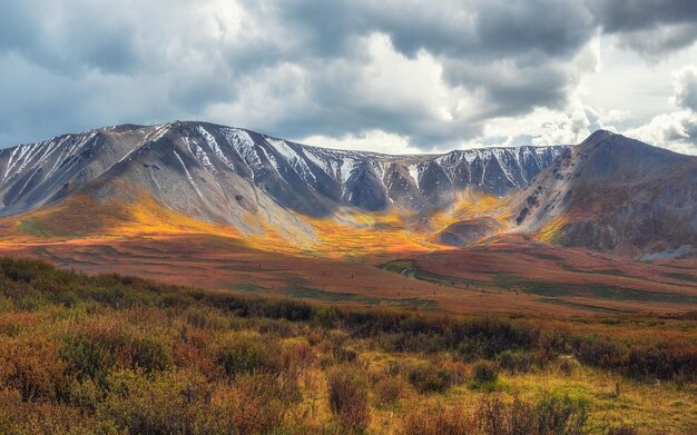 Picturesque autumn mountain plateau with a dramatic view and rays of the sun on the hillside