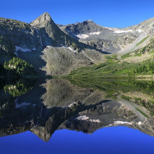 Foto pittoresco lago nelle montagne altai con la riflessione su una mattina d'estate