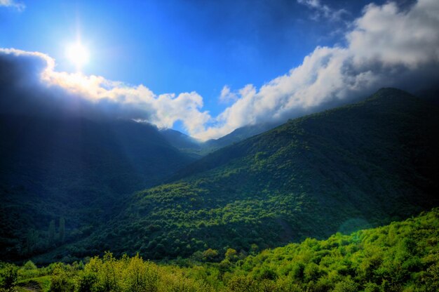 Picturesque landscape, rain clouds, mountains covered with green plants, country road passes among hills