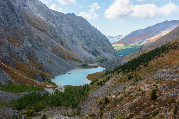 Picturesque landscape with blue alpine lake in colorful autumn valley Top view to azure mountain lake among multicolor flora Vivid autumn colors in high mountains Aerial view to beautiful lake