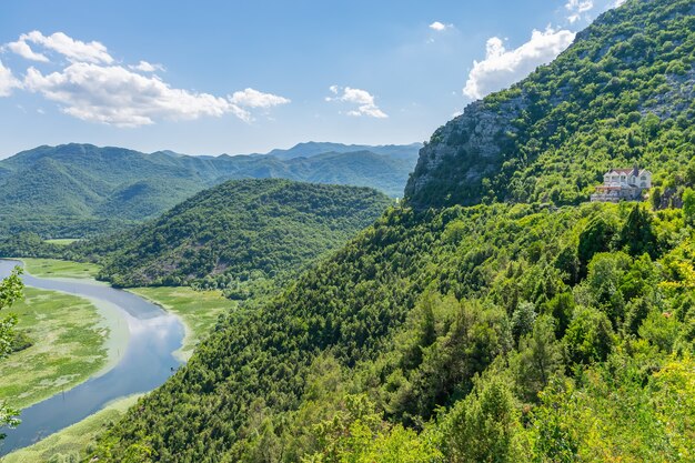 Живописная извилистая река протекает среди зеленых гор.
