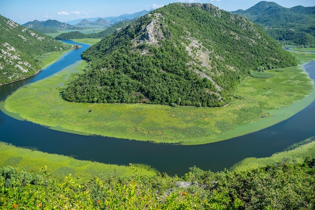 The picturesque meandering river flows among green mountains