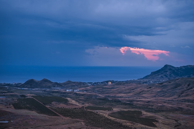 A picturesque mountain landscape at dawn with a dramatic sky Colorful travel background