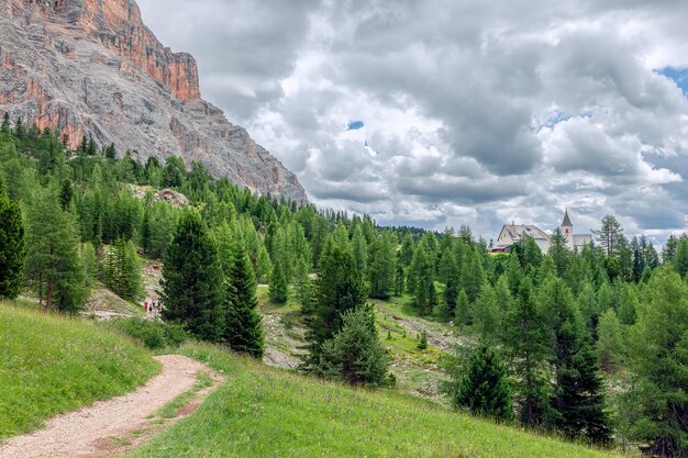 A picturesque path through an alpine meadow in the Italian Dolomites for hiking and cycling