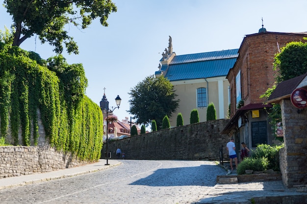 Picturesque paved street and the Trinitarsky church in historic city of Kamianets-Podilskyi, Ukraine