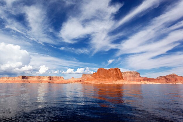 Picturesque red cliffs reflected in the smooth water of the lake Powell