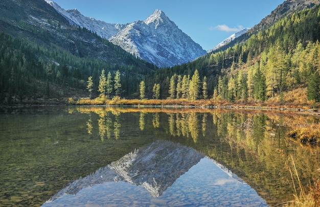 Picturesque reflection of peaks in a mountain lake autumn morning wild places