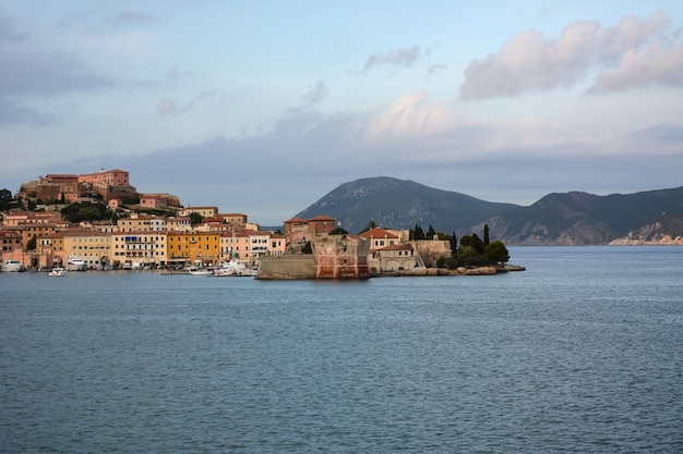 イタリア の 町 の 絵画 的 な 海岸 と 背景 に ある 様々 な 小さな 家 と 山