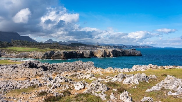 スペイン北部アストゥリアスの背景に崖と緑の山々がある絵のように美しい海の風景