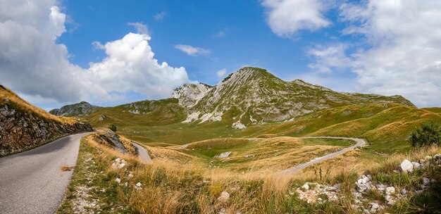 Picturesque summer mountain landscape of Durmitor National Park Montenegro Europe Balkans Dinaric Alps Durmitor panoramic road Sedlo pass Motorcyclist and motorcycle model unrecognizable