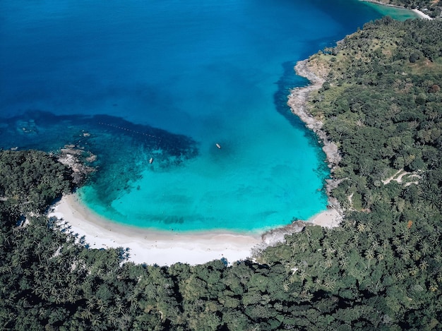 Picturesque top view of a huge white catamaran sailing across the deep sea. Aerial view.