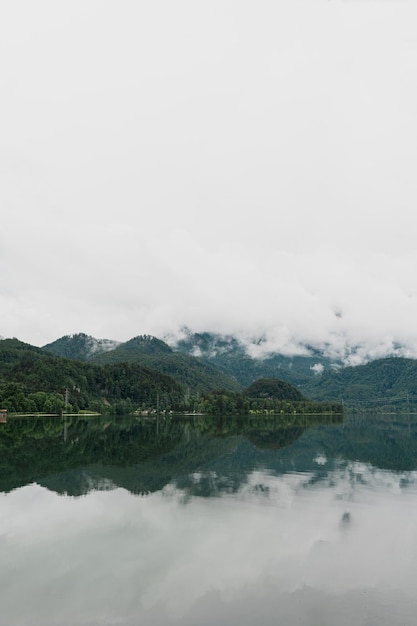 Фото Живописный вид на озеро с отражениями гор и облаков. живописный идиллический спокойный пейзаж.
