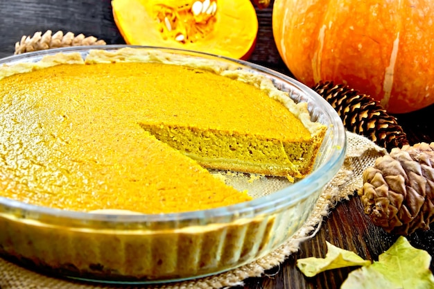 Pie pumpkin in pan on board