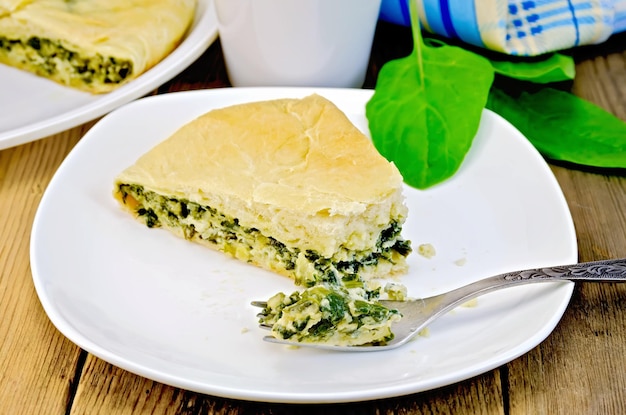 Pie spinach and cheese with fork on board