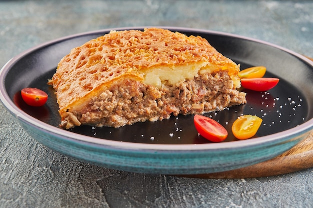 Pie with beef tourtiere and cherry tomatoes pie with minced\
meat