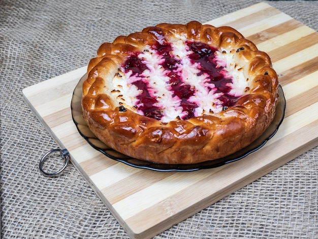 Pie with cherries and cottage cheese on a wooden Board.