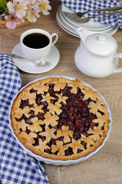 Pie with cherry filling decorated flowers and petals